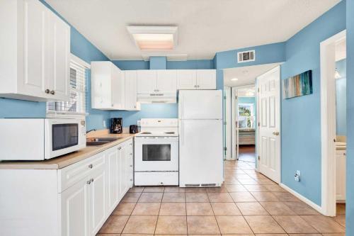 a kitchen with white appliances and blue walls at Ocean front Rental 101-2 in Tybee Island