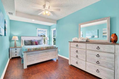 a bedroom with a bed and a dresser with a mirror at Ocean front Rental 101-2 in Tybee Island