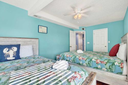 a bedroom with two beds and a ceiling fan at Ocean front Rental 101-2 in Tybee Island