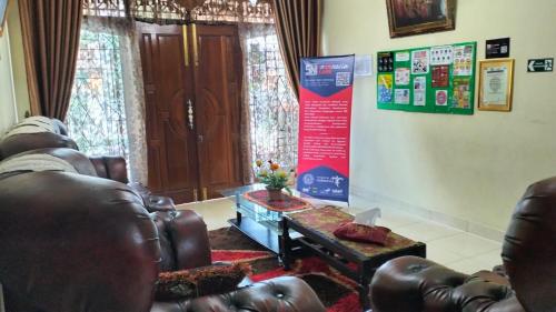 a living room with a leather couch and a table at Dahniar Syariah Homestay in Baso