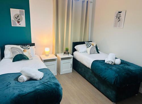a bedroom with two beds and two tables at Waterside Stay- 3 Bed House- Sleeps 5- Parking- Fast Wifi in Burton upon Trent