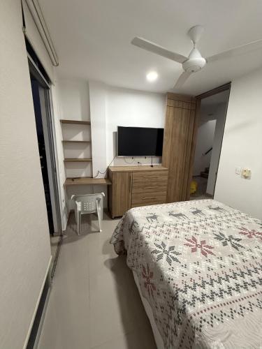 a bedroom with a bed and a flat screen tv at Casa Quinta con piscina Girardot- Via el Peñón in Girardot