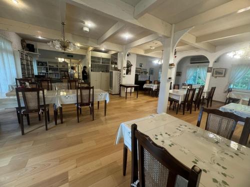 a restaurant with tables and chairs and a dining room at TERUKA白いテラスHakuba in Hakuba