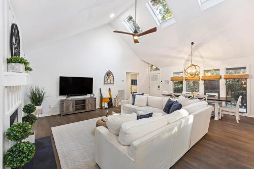 a living room with white furniture and a flat screen tv at SI2995: 2995 Seabrook Island Rd. in Seabrook Island