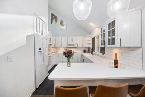 a kitchen with white cabinets and a vase of flowers on a counter at SI2995: 2995 Seabrook Island Rd. in Seabrook Island