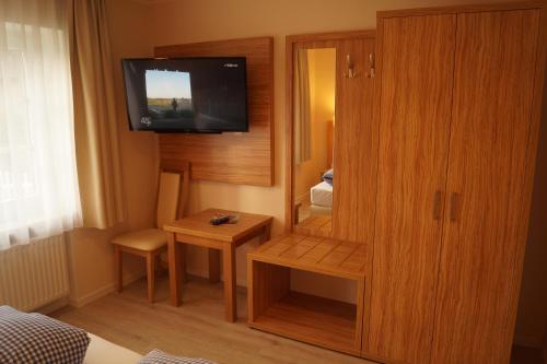 a small room with a television and a small table at Landhotel Klempau in Lübeck