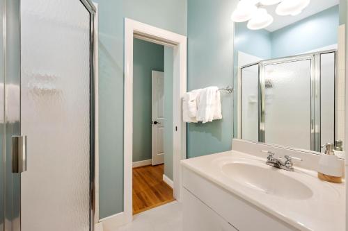 a white bathroom with a sink and a mirror at SM14: 14 Silver Moss in Kiawah Island