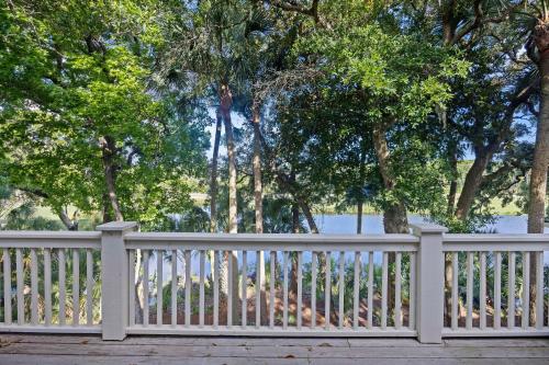 a white fence in front of trees and water at SM14: 14 Silver Moss in Kiawah Island