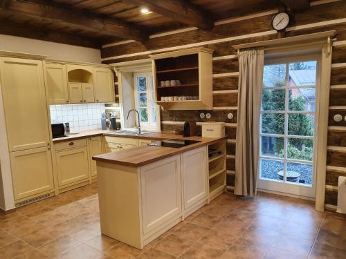 una cucina con mobili bianchi e una grande finestra di Villa in Cerna Hora near Ski Slopes a Horní Maršov