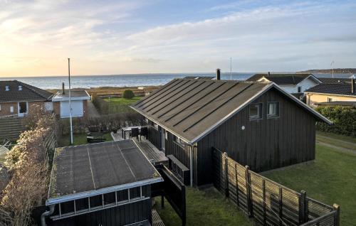 a house with a wooden roof with the ocean in the background at Stunning Home In Haderslev With Wifi in Haderslev