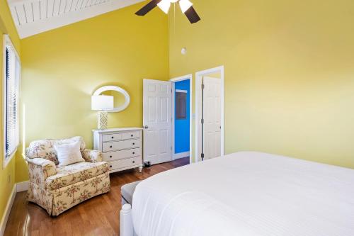 a bedroom with a bed and a chair and a dresser at SL912: 912 Sealoft in Seabrook Island