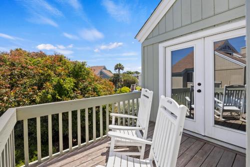 a pair of white chairs sitting on a deck at SL912: 912 Sealoft in Seabrook Island