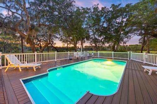 a pool on a deck with a bench and a chair at MG3080: 3080 Marshgate in Seabrook Island