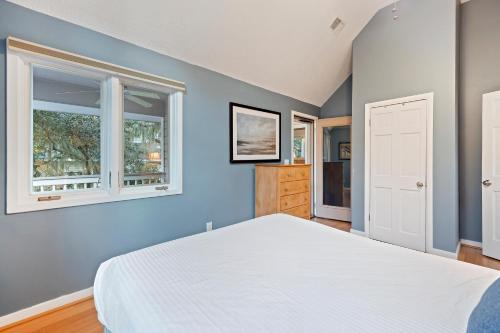 a bedroom with a white bed and two windows at MG3080: 3080 Marshgate in Seabrook Island