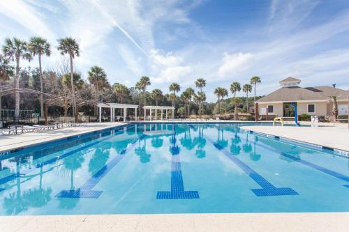 a swimming pool at a resort with palm trees at MG3080: 3080 Marshgate in Seabrook Island