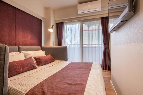 a bedroom with a large bed with red pillows at ACROSS Akihabara in Tokyo