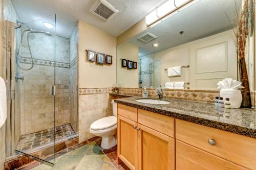 Un baño con ducha, inodoro y lavabo. en Greystone Lodge 408 Luxury, en Whistler