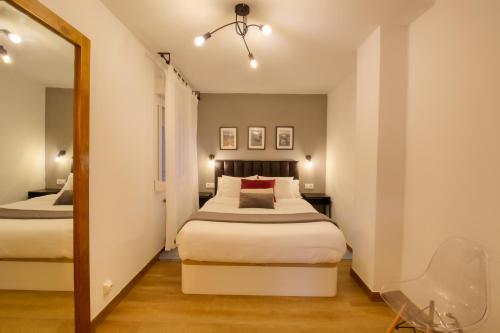 a bedroom with a bed and a mirror at Apartamentos en Gascona Centro de Oviedo Apartastur26 in Oviedo