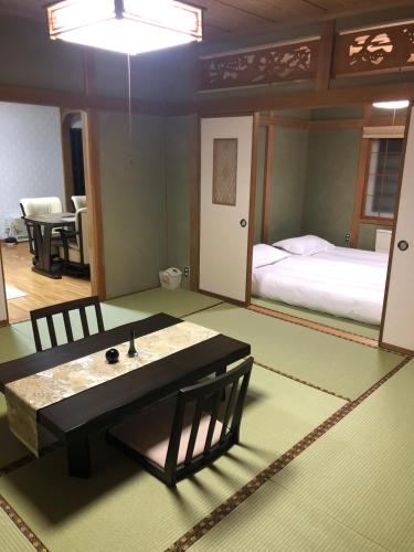 a room with a bed and a table and chairs at 小樽祝津山荘2号楼 in Otaru