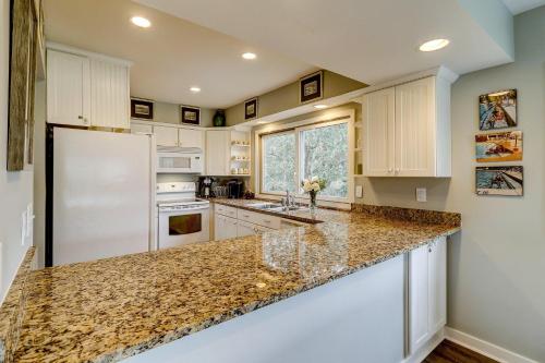a kitchen with white cabinets and granite counter tops at SG8C: 8C Seagrove Villa in Isle of Palms