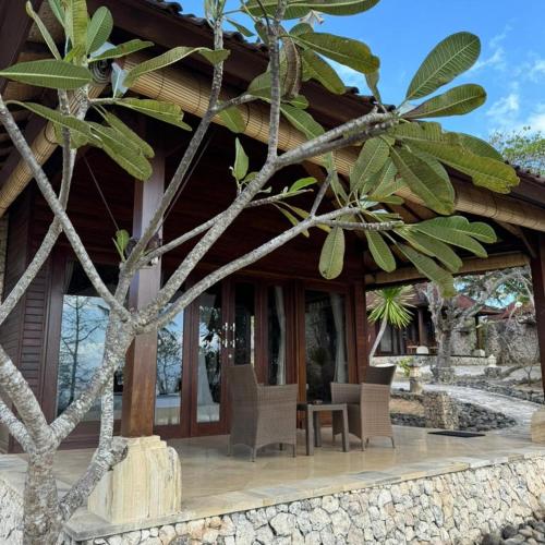 a wooden house with chairs in front of it at Rady Lembongan in Nusa Lembongan