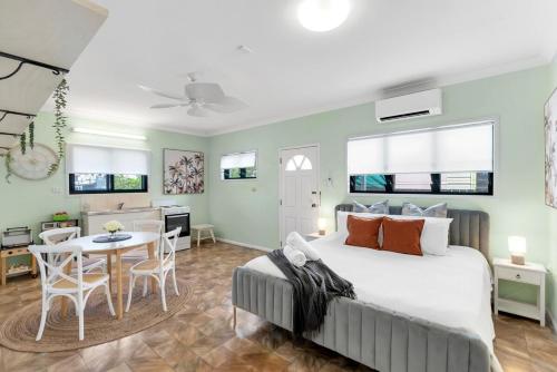 a bedroom with a bed and a dining room at The Oasis - Charming Family Retreat on City Fringe in Cairns