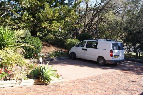 a white van is parked in a driveway at Beachside Haven Free Linen Wi-Fi Netflix air con in Boomerang Beach