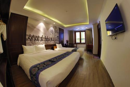 a hotel room with two beds and a tv at Delta Sapa Hotel - Old Quarter Center in Sa Pa