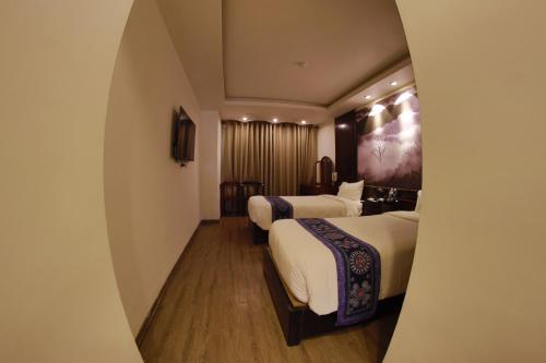 a hotel room with two beds and a hallway at Delta Sapa Hotel - Old Quarter Center in Sa Pa