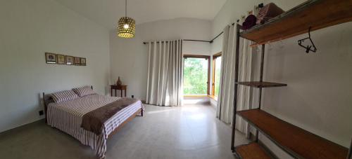 a bedroom with a bed and a window at Casa Suíte À 800 Mts do Parq Chapada dos Veadeiros in Alto Paraíso de Goiás