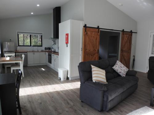 a living room with a couch and a kitchen at Halls Gap Cottages in Halls Gap