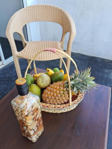 a basket of fruit on a table with a chair at RKO Villa27 - Unawatuna in Habaraduwa