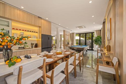 ein Esszimmer mit einem Billardtisch und Stühlen in der Unterkunft Sense Pool Villa - Luxurious 500m2 Pool Mansion Walk to My Khe Beach in Đà Nẵng