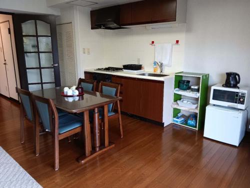 a small kitchen with a table and a refrigerator at 金閣莊 private onsen by reservation for free in Hakone