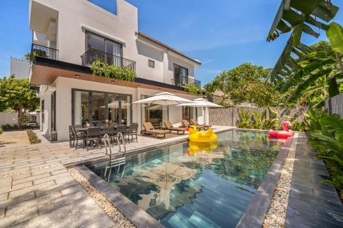 ein Haus mit einem Pool mit einem Haus in der Unterkunft Sense Pool Villa - Luxurious 500m2 Pool Mansion Walk to My Khe Beach in Đà Nẵng