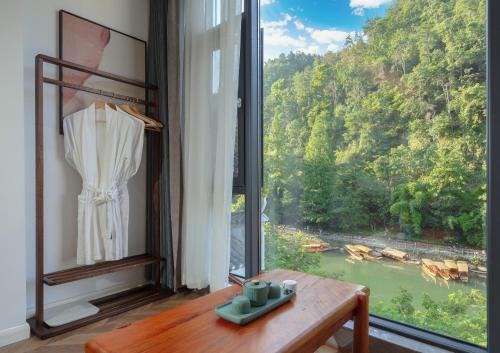 a room with a window with a view of a river at 凤凰苇渡庭院江景民宿 in Fenghuang