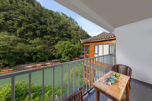 a balcony with a table and a view at 凤凰苇渡庭院江景民宿 in Fenghuang