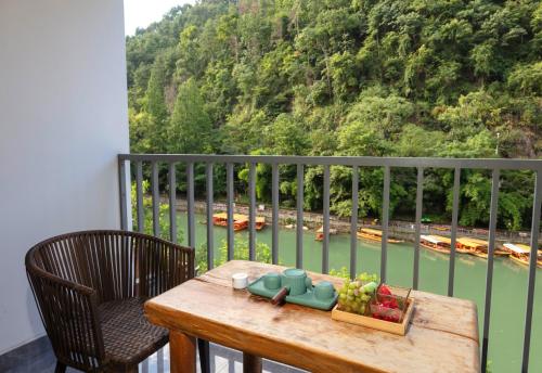 a table on a balcony with a view of a river at 凤凰苇渡庭院江景民宿 in Fenghuang