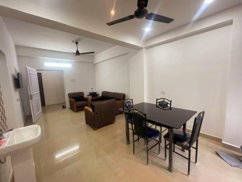 a living room with a dining room table and a ceiling fan at Classic Homes Airport in Guwahati