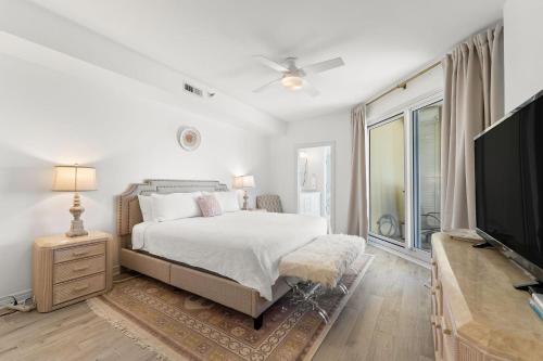 a bedroom with a bed and a flat screen tv at Beach Colony West 1C in Pensacola