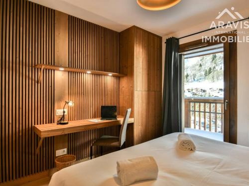 une chambre avec un lit, un bureau et une fenêtre dans l'établissement Appartement neuf aux pistes, parking, Wi-Fi, balcon, 6 pers - FR-1-391-188, au Grand-Bornand