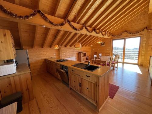 - une cuisine et une salle à manger dans une cabane en rondins dans l'établissement Chalet spacieux avec balcon et cuisine équipée - FR-1-787-112, à Laveissière