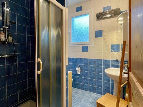 a blue tiled bathroom with a shower and a sink at Chambre cosy avec terrasse et jardin proche Puy-en-Velay - FR-1-582-526 in Saint-Germain-Laprade