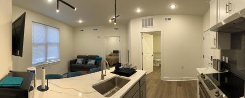 a kitchen with a sink and a living room at Church Hill Apt - TH02 - Tourist Homes of Richmond in Richmond