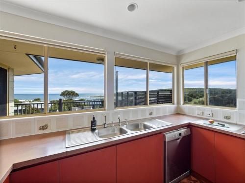 una cocina con 2 lavabos y una ventana grande en Grandview Holiday Beach House, en Gracetown