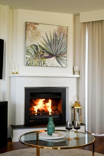 a living room with a fireplace and a glass table at Mount Bold Estate - Luxurious Private Retreat in Kangarilla