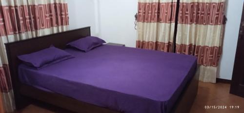 a purple bed with purple pillows in a bedroom at Vino Villa Tourists & Local Accommodations - 24 Hrs in Kandy