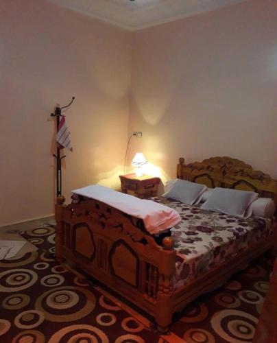 a bedroom with a large bed with a lamp on it at Tata Guest House in Tatta