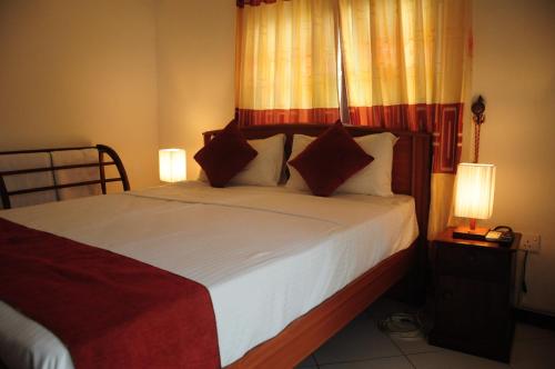 a bedroom with a bed with white sheets and pillows at Vino Villa Tourists & Local Accommodations - 24 Hrs in Kandy