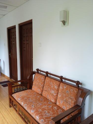 a couch sitting in a room with a wall at Vino Villa Tourists & Local Accommodations - 24 Hrs in Kandy